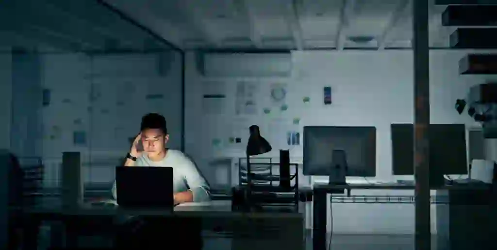 man sitting in the dark on a computer